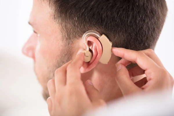 Pessoa colocando aparelho auditivo — Fotografia de Stock