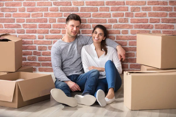 Pareja sentada entre cajas —  Fotos de Stock