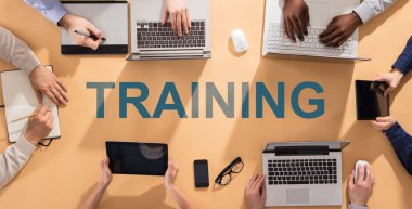 Dizüstü bilgisayarlar ve dijital tablet kullanarak masa üzerinde Word eğitim ile işadamları'nın el havai görünümü