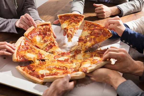 Empresários levando fatias de pizza — Fotografia de Stock