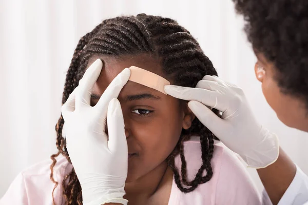 Médico aplicando Band Aid Girl — Fotografia de Stock