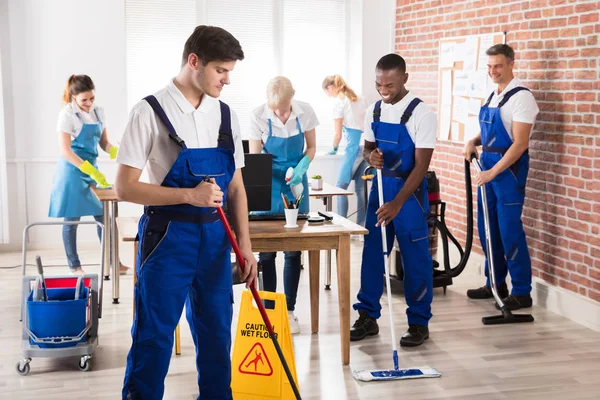 Gruppe Diverser Hausmeister Uniform Die Das Büro Mit Reinigungsgeräten Säubern — Stockfoto