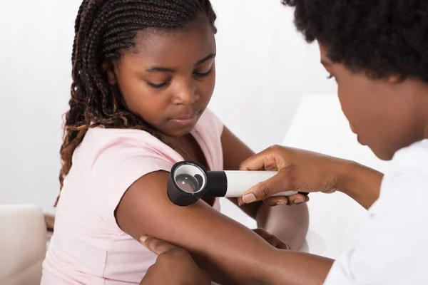 Médico examinando a pele da menina — Fotografia de Stock