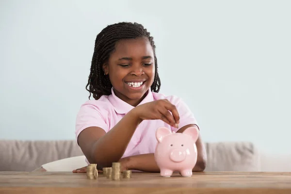 Chica africana insertando monedas — Foto de Stock