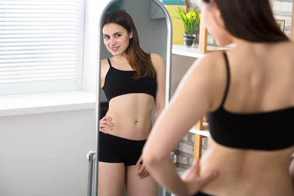 Vrouw kijken naar spiegelbeeld — Stockfoto