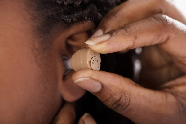 Doctor Inserting Hearing Aid — Stock Photo, Image