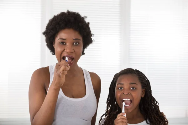 Mãe e filha escovando os dentes — Fotografia de Stock