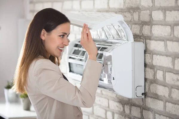 Vrouw Opening airconditioner — Stockfoto