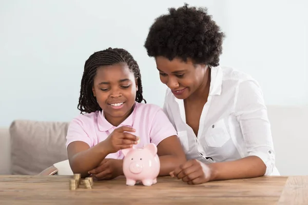 Mãe Inserindo Moedas Em Piggy Bank — Fotografia de Stock