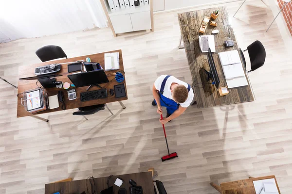Janitor piso de limpeza com Vassoura — Fotografia de Stock