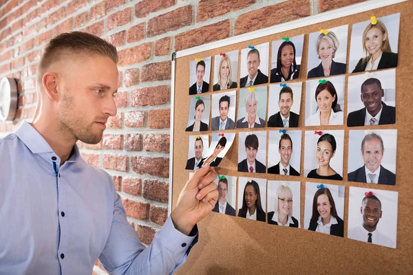 Businessman Selecting Candidates Photo Attached Corkboard Office — Stock Photo, Image