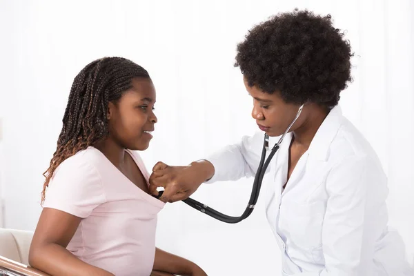 Mujer médico examinando paciente — Foto de Stock