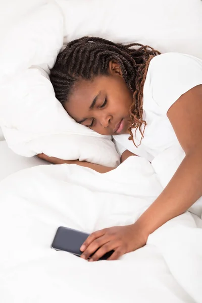 Africká dívka ležící na posteli — Stock fotografie