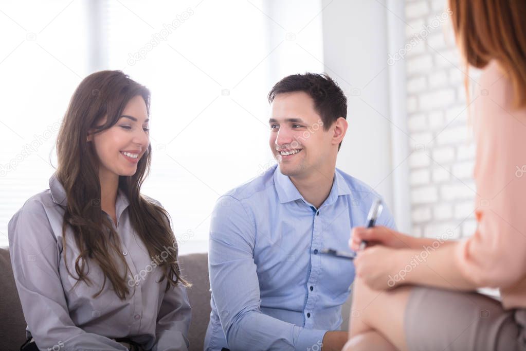 Portrait Of Young Smiling Couple With Consultant