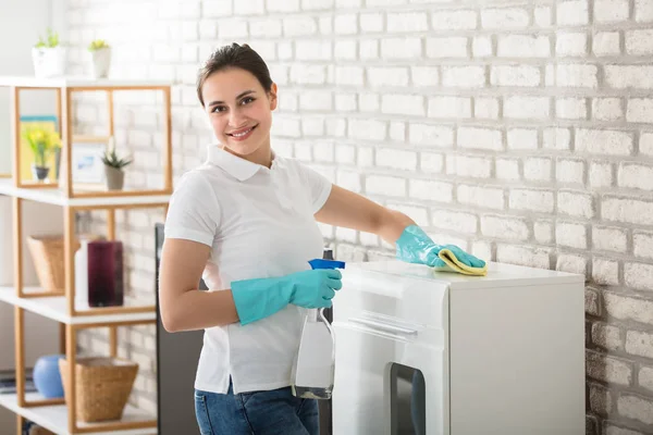 Jonge vrouw schoonmaken kabinet — Stockfoto