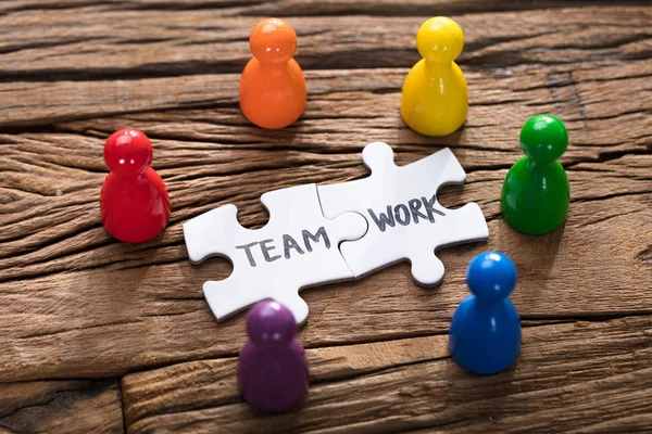 Teamwork Jigsaw stukken en pion beeldjes — Stockfoto