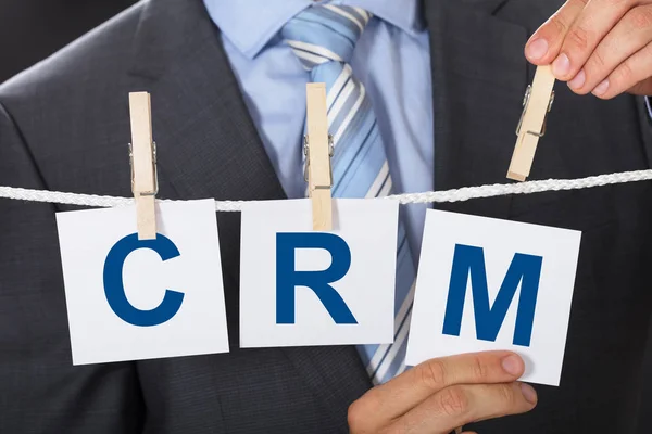 Бизнесмен наклеивает бумажки CRM на одежду — стоковое фото