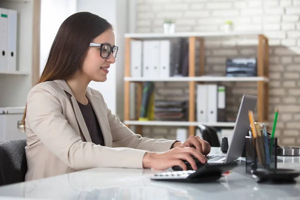 Femme d'affaires utilisant un ordinateur portable sur le lieu de travail — Photo