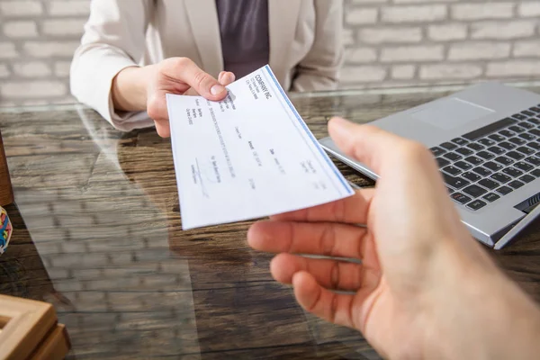 Businesswoman giving check to colleague — Stock Photo, Image