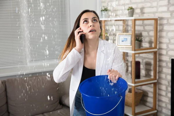 Kvinnan ringer rörmokaren för vattenläckage — Stockfoto