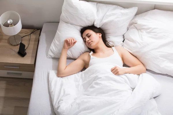 Жінка, що спить на білу ліжко — стокове фото