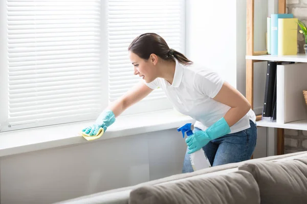 Mujer limpieza ventana alféizar con trapo —  Fotos de Stock