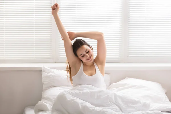 Wanita peregangan di tempat tidur — Stok Foto