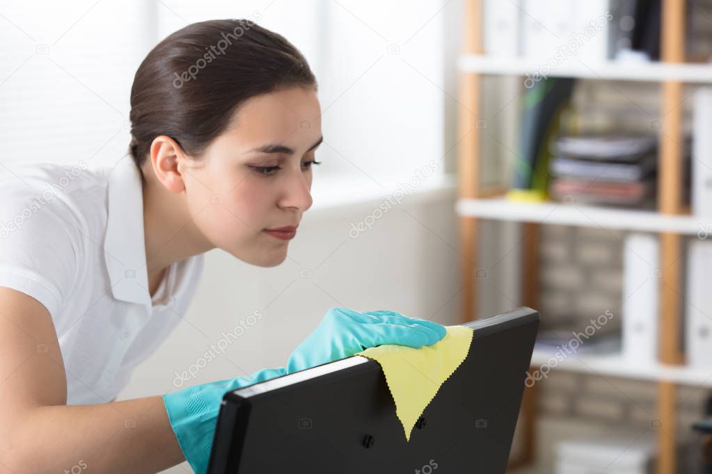 Woman Cleaning Desktop With Rag