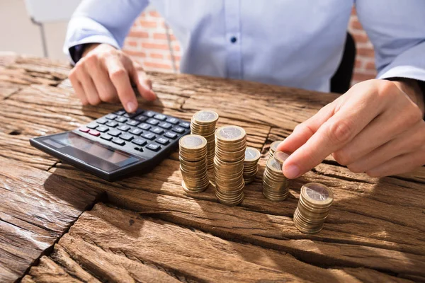 Homem de negócios calculando moedas — Fotografia de Stock