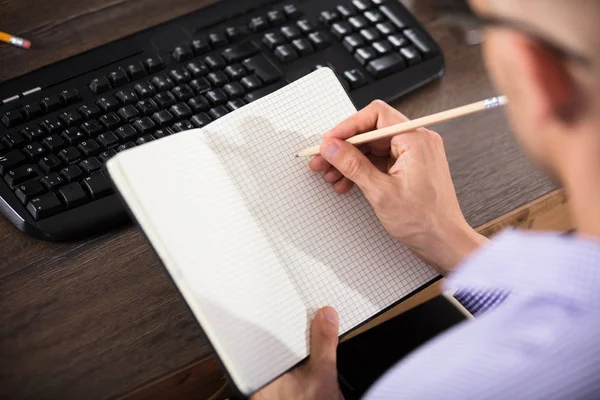 Empresário escrevendo em notebook — Fotografia de Stock