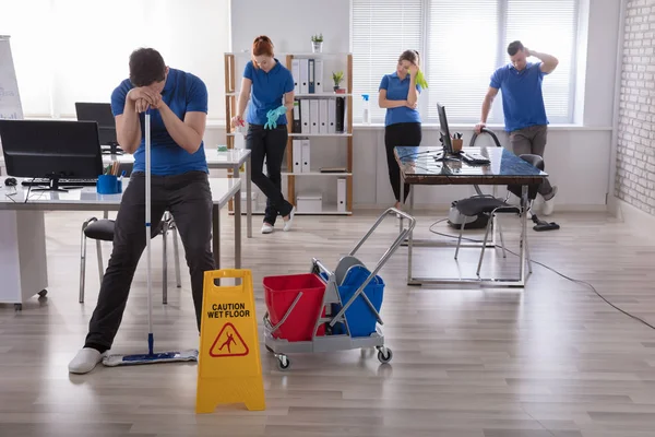 Gruppe Müder Hausmeister Uniform Mit Reinigungsgeräten Büro — Stockfoto