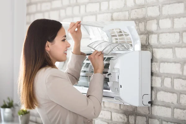 Vrouw schoonmaken airconditioner — Stockfoto