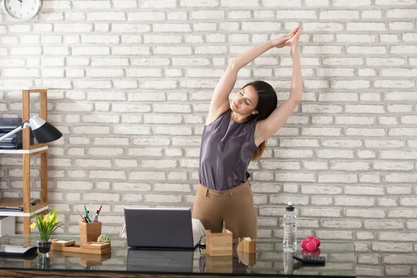 Imprenditrice stretching in ufficio — Foto Stock