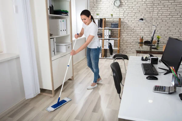 Junge Frau putzt Fußboden — Stockfoto