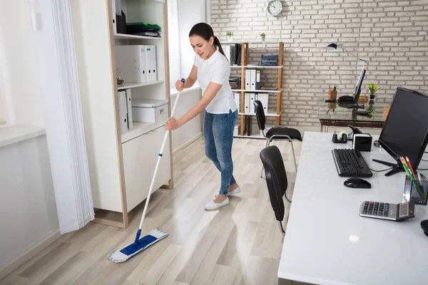 Jonge vrouw schoonmaak vloer — Stockfoto