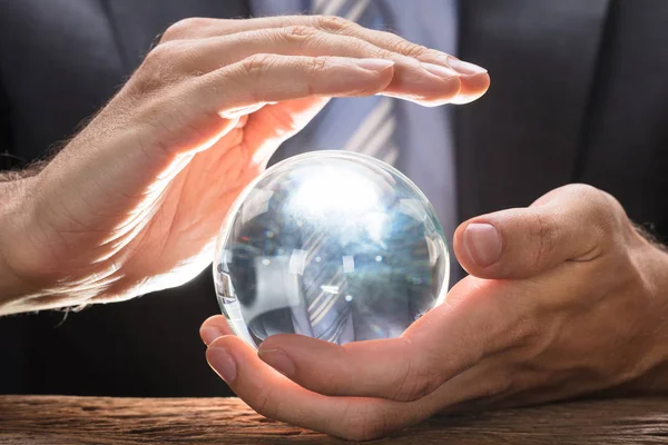 Empresário que cobre a bola de cristal — Fotografia de Stock
