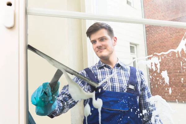 Huishoudster schoonmaak venster — Stockfoto