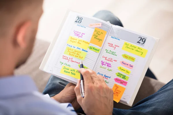 Mann schreibt Notizen ins Tagebuch — Stockfoto