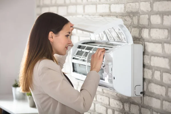 Vrouw Opening airconditioner — Stockfoto