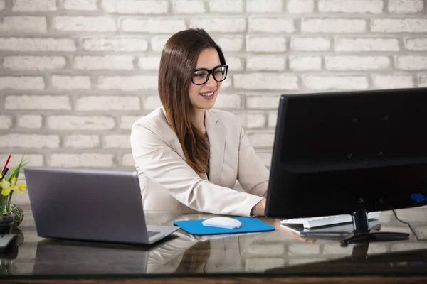 Empresária sorridente usando computador — Fotografia de Stock