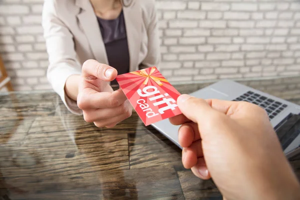 Personne donnant la carte-cadeau à la femme d'affaires — Photo