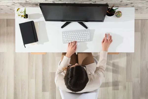 Жінка використовує комп'ютер в офісі — стокове фото