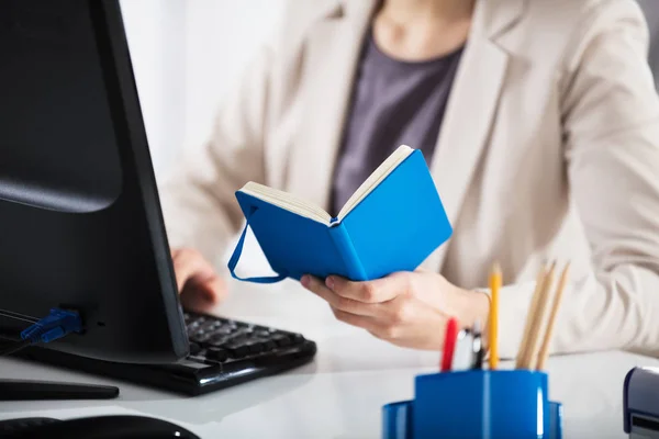 Mujer de negocios sosteniendo diario — Foto de Stock