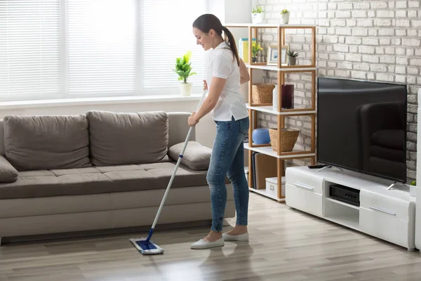 Jonge vrouw schoonmaak vloer — Stockfoto