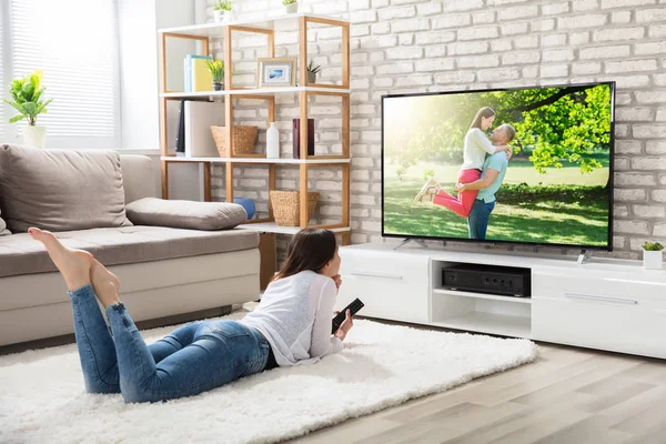 Женщина смотрит телевизор дома — стоковое фото