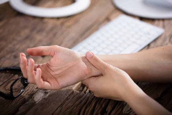 Näringsidkare som håller smärtsamma handled — Stockfoto