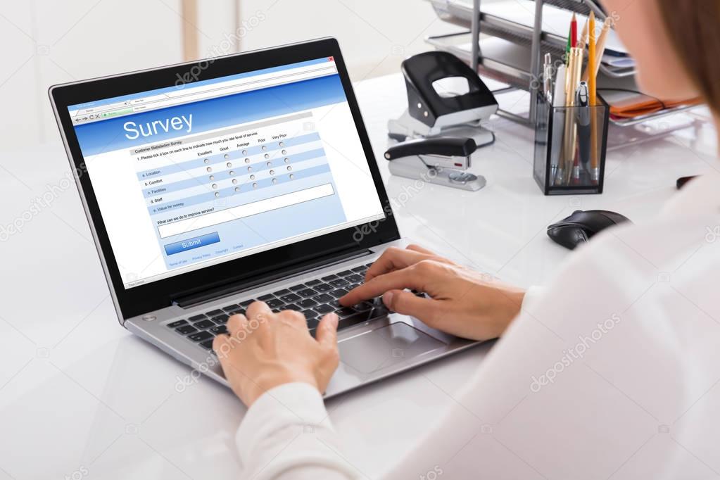 Businesswoman Filling Survey On Laptop