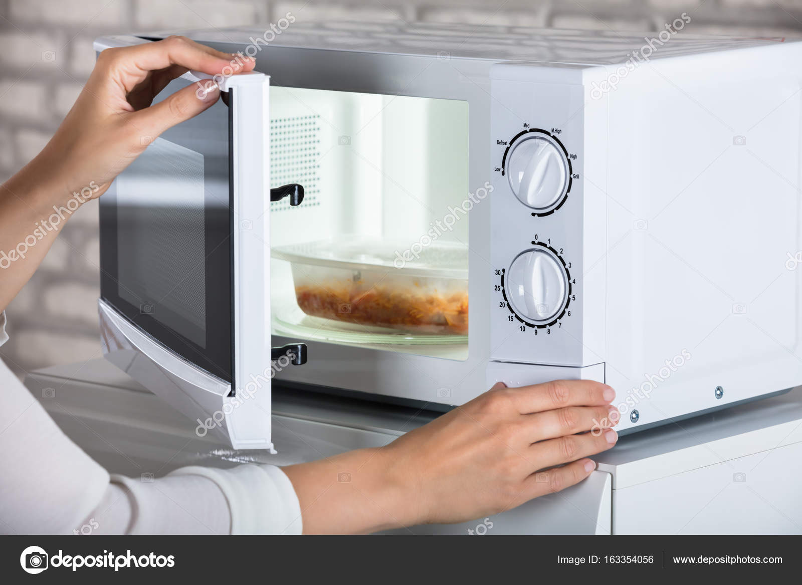 Woman Closing Microwave Oven — Stock Photo © AndreyPopov #163354056
