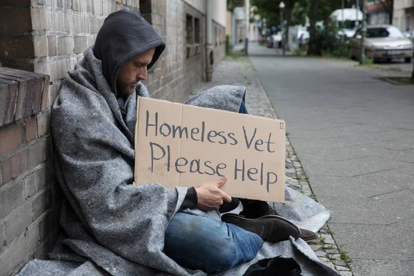 Hombre sin hogar sentado en la calle — Foto de Stock