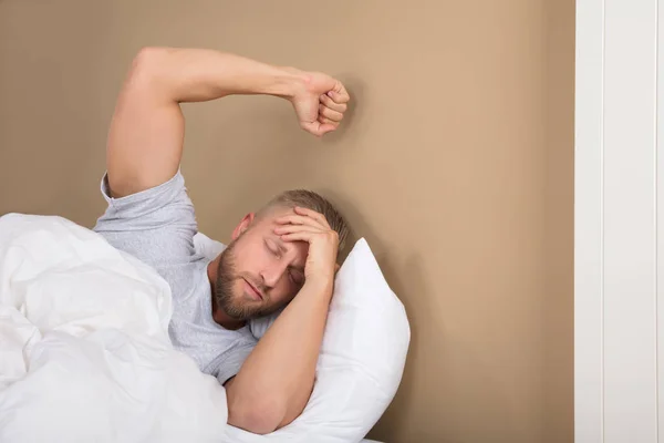 Muž ležící na posteli — Stock fotografie